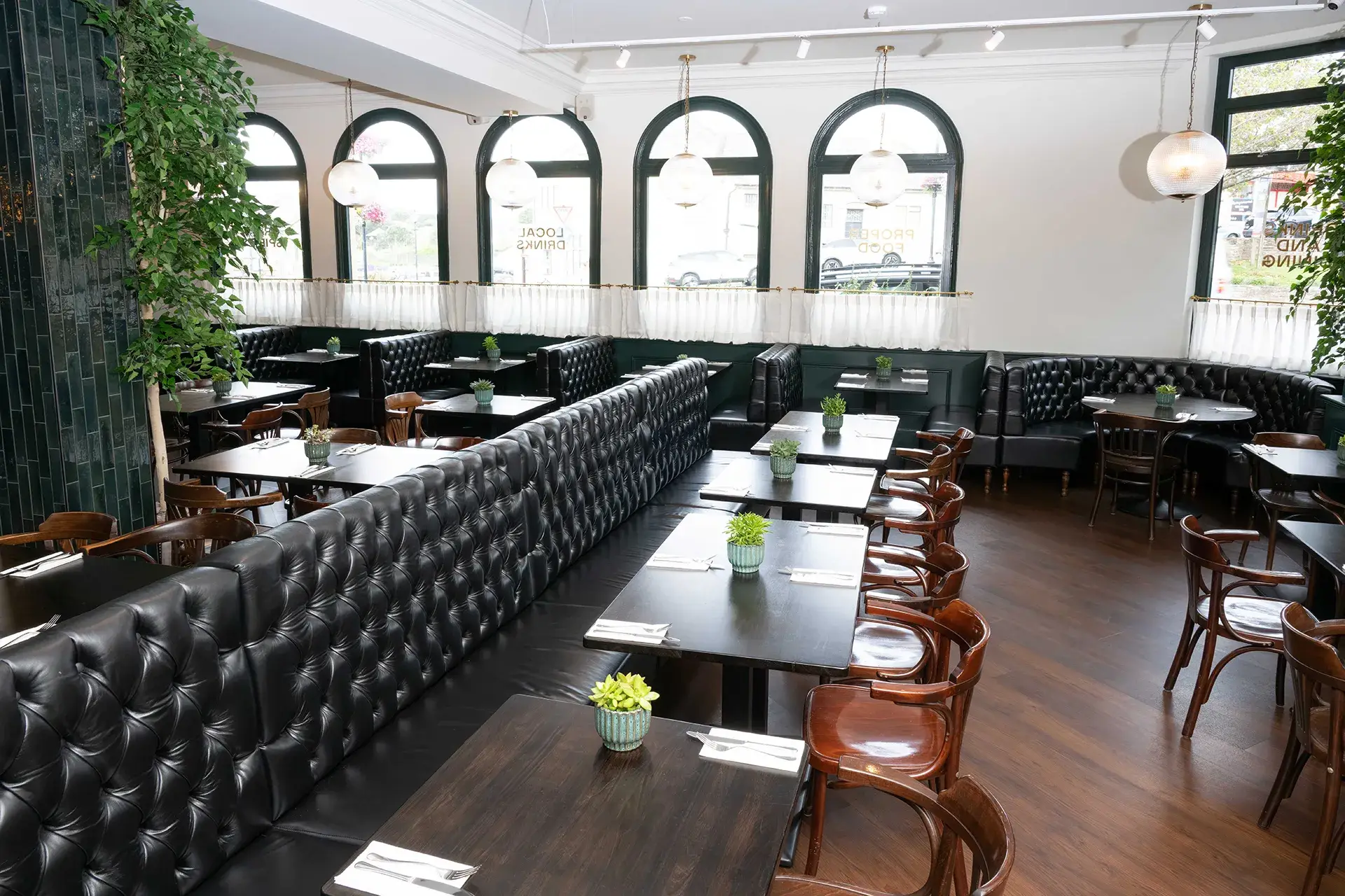 Black leather banquette seating in a bright restaurant interior